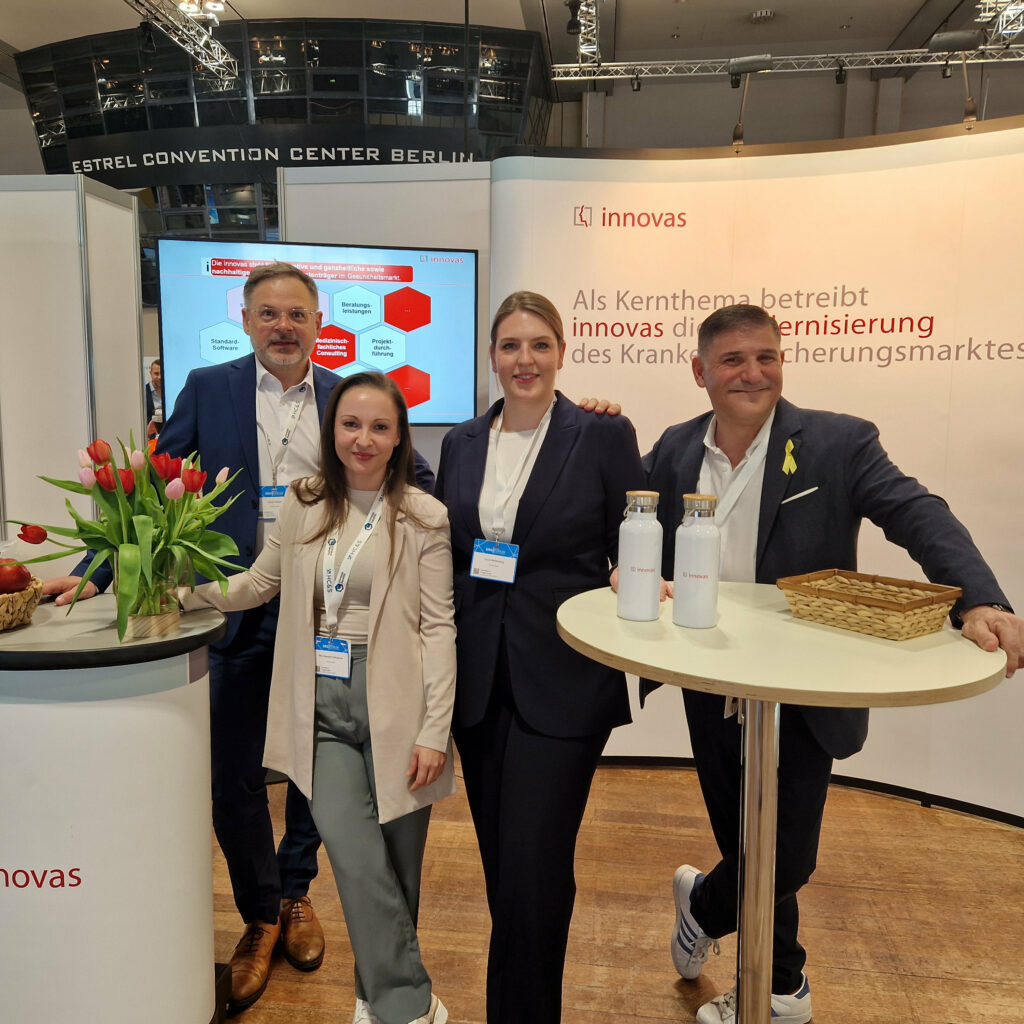 Vier innovas-Mitarbeitende stehen vor unserem Messestand