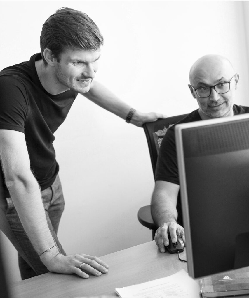 Zwei innovas-Mitarbeitende im Gespräch an einem PC