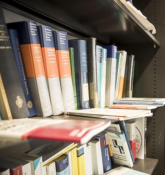 Ein Bücherregal mit verschiedenen medizinischen Büchern ist abgebildet.