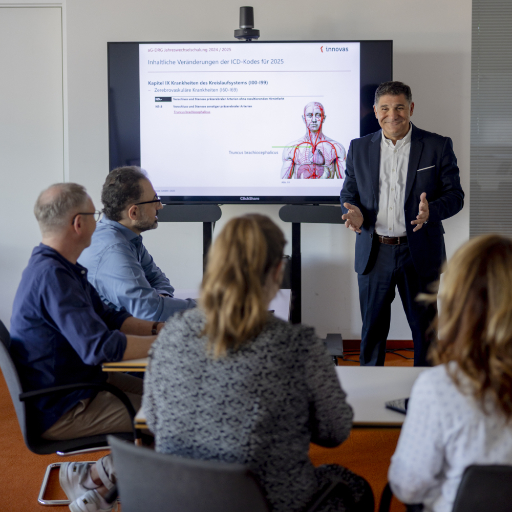 Eine Schulungssituation mit einem Referenten und mehreren innovas-Mitarbeitenden.