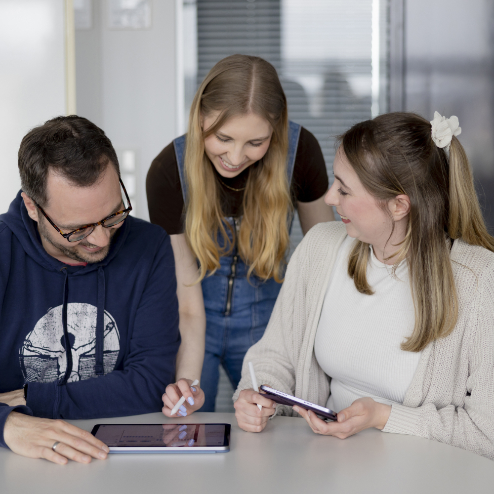 Drei innovas-Ma sind mit verschiedenen mobilen Endgeräten ein einer Besprechung.