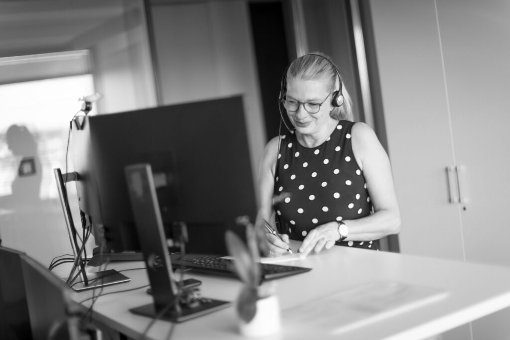 Eine innovas-Mitarbeitende telefoniert mit ihrem Headset