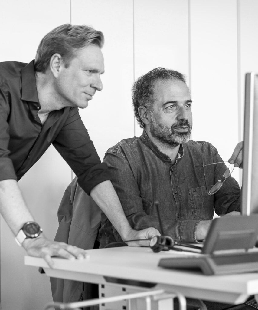 Zwei innovas-Mitarbeitende schauen gemeinsamen auf einen Monitor