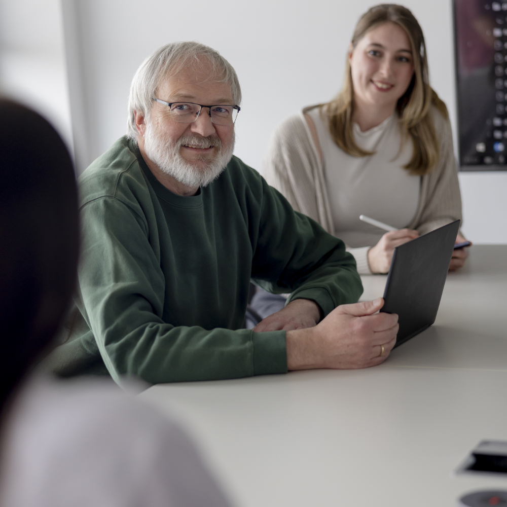 Zwei innovas-MA sitzen an einem Besprechungstisch.