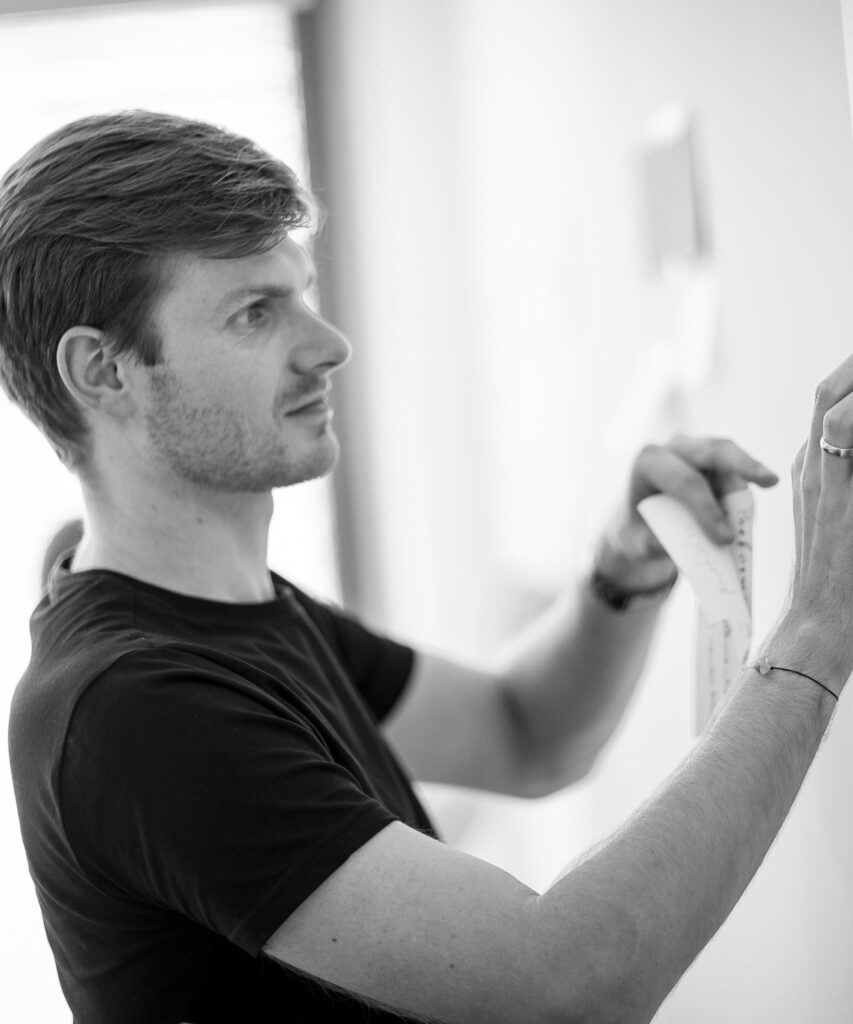 Ein innovas-Mitarbeitender klebt Post-It's an ein Whiteboard