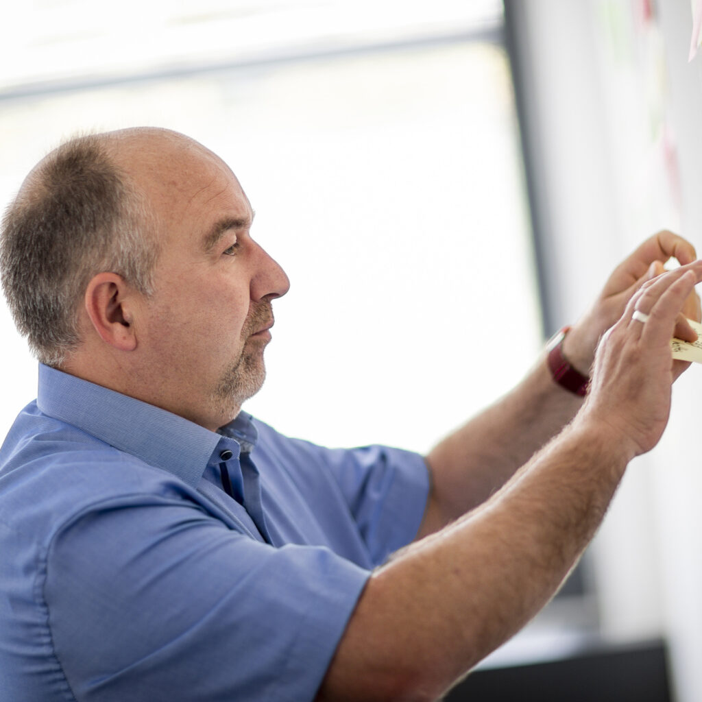 Ein innovas-Mitarbeitender steht vor einem Whiteboard.