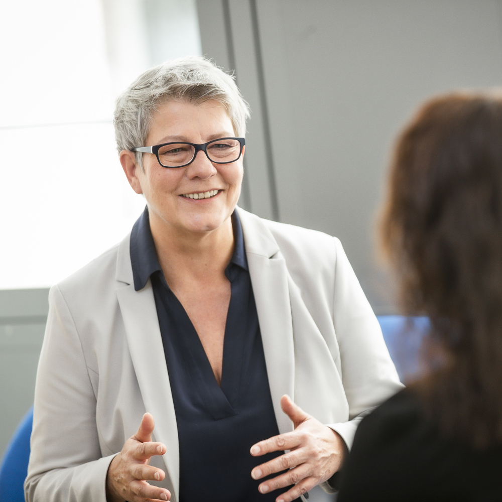 Eine innovas-Mitarbeitende ist im Gespräch mit einer weiteren innovas Mitarbeitenden.