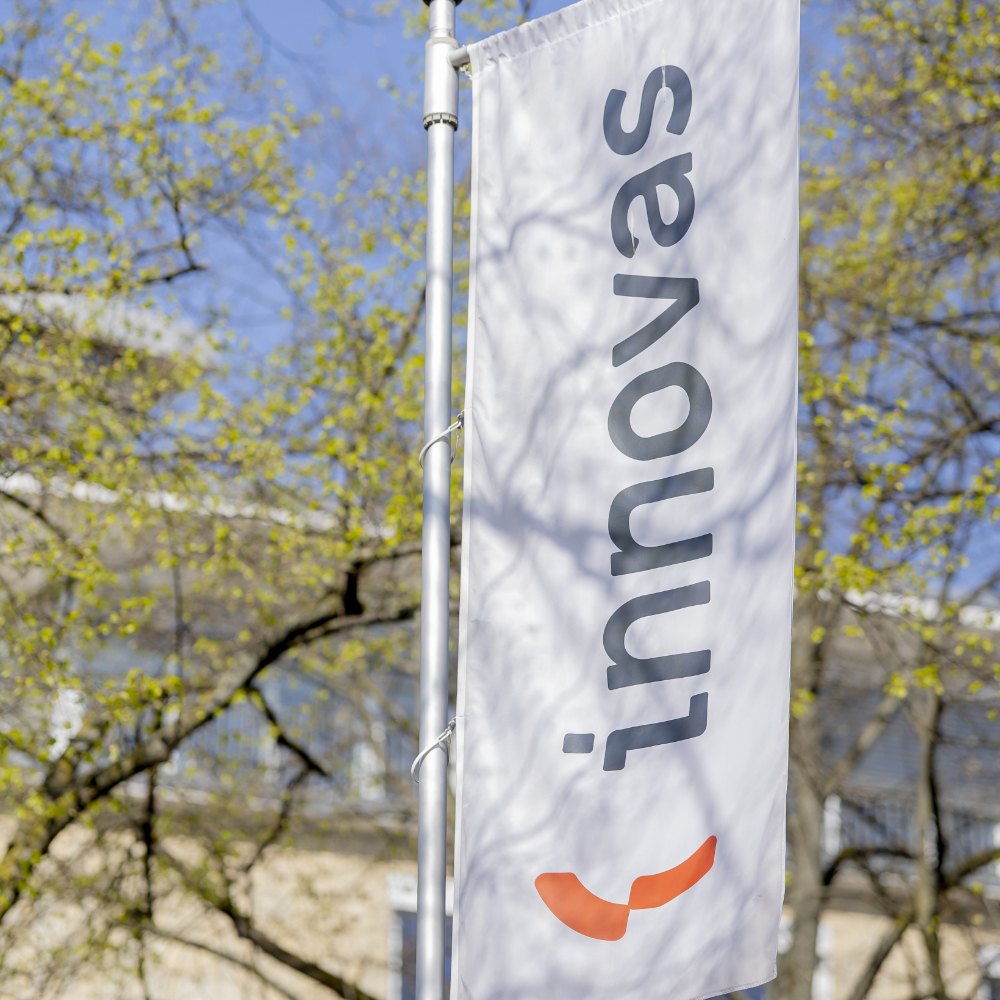 Die Fahne mit dem innovas-Logo vor dem Firmengebäude.