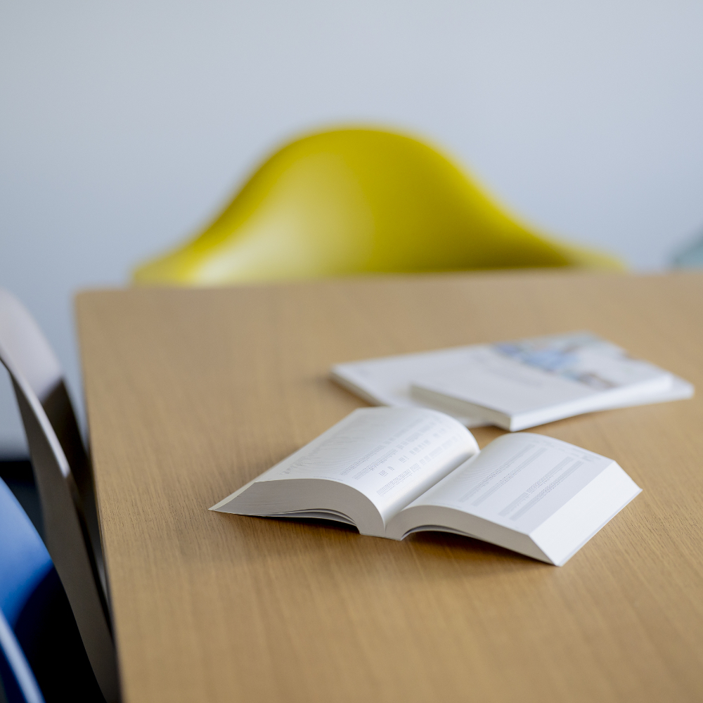 Aufgeschlagene Bücher auf einem Tisch.