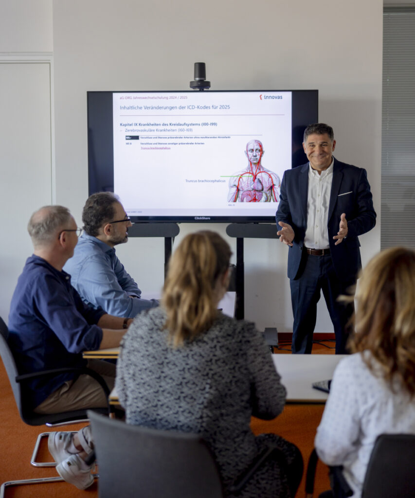 Eine Gruppe innovas-Mitarbeitender wird geschult. Im Hintergrund ist ein großer monitor zu sehen.