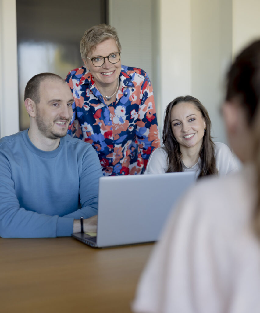 Eine kleine Gruppe innovas-Mitarbeitende bespricht sich in einem Besprechungsraum.